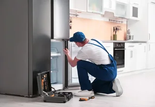 Professional technician repairing refrigerator and washing machineat home in Islamabad